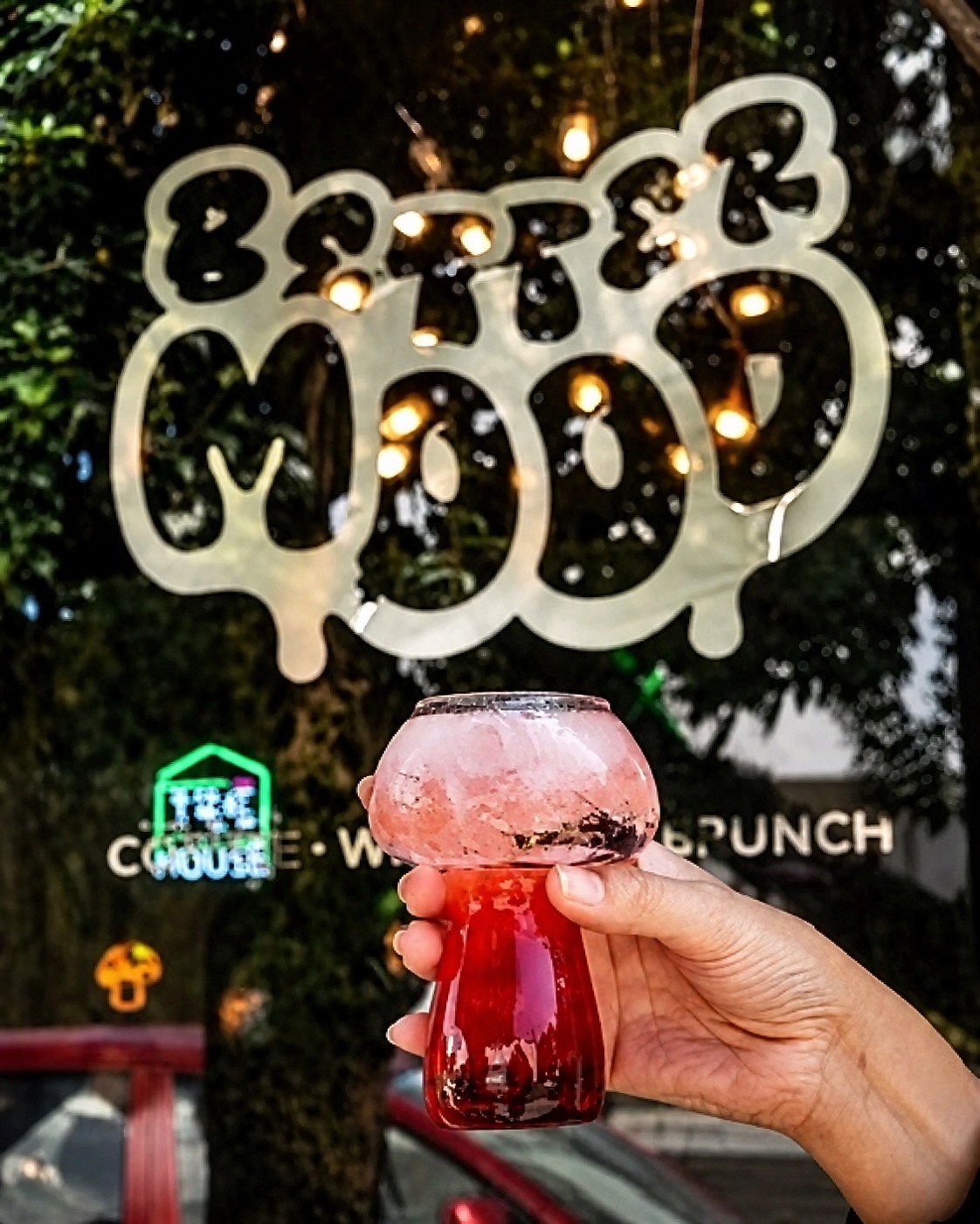 Vaso en forma de hongo frente al letrero de Better Mood Coffee