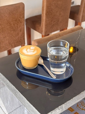 Latte y vaso de agua servidos en Better Mood Coffee